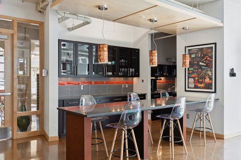 a kitchen with a long counter and chairs